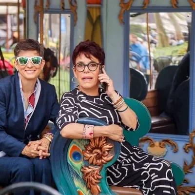 Two women sitting on a colorful train car.